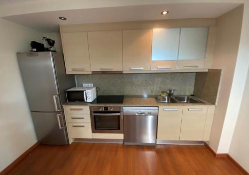 a kitchen with white cabinets and a stainless steel refrigerator at Apartament l'Areny 21 - 6p - Canillo - Zona Grandvalira in Canillo