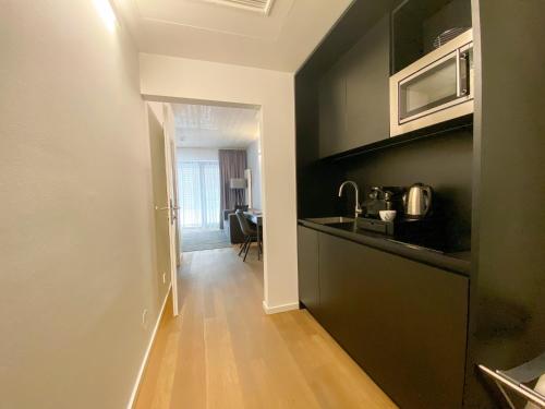 a kitchen with a counter top and a hallway at Blackhome Graz I contactless check-in in Graz