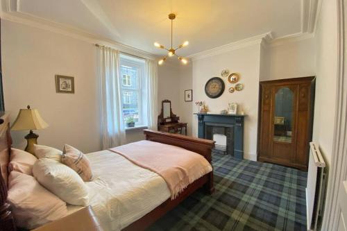 um quarto com uma cama e uma lareira em Old City Gem Flat em Aberdeen