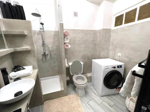 a bathroom with a toilet and a sink and a shower at Calvi T2 climatisé, wifi, centre-ville, à proximité plage, commerces, taxi & gare, vue plage & montagne in Calvi