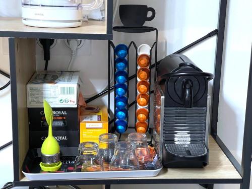 a shelf with a coffee maker and other items on it at Calvi T2 climatisé, wifi, centre-ville, à proximité plage, commerces, taxi & gare, vue plage & montagne in Calvi