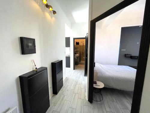 a bedroom with a large mirror and a bed and a tv at Calvi T2 climatisé, wifi, centre-ville, à proximité plage, commerces, taxi & gare, vue plage & montagne in Calvi