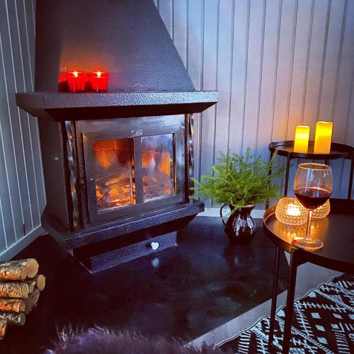 a fireplace in a room with a table with a glass of wine at Gråbogården event and conference center in Gråbo
