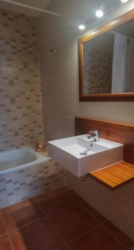 a bathroom with a white sink and a tub at sanluis in Daimuz