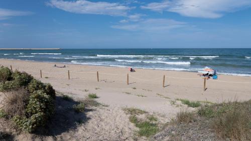 a beach with people in the water and the ocean at sanluis in Daimuz