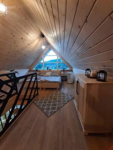 a room with a bed and a staircase in a house at Mała Gorczańska Chatka in Ochotnica Dolna