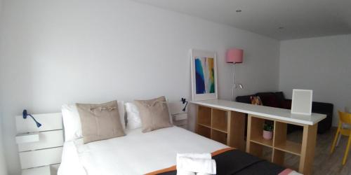 a bedroom with a white bed and a desk at Tomarhousing - Old Town in Tomar