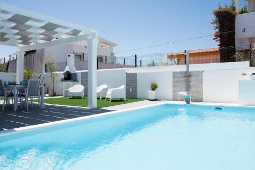 a swimming pool in a backyard with a villa at Casa Lusitana da Praia & Casa Lusitana Mare Alta in Porto Covo