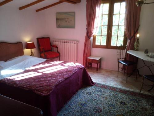 1 dormitorio con cama, mesa y ventanas en Roubies, en Mons