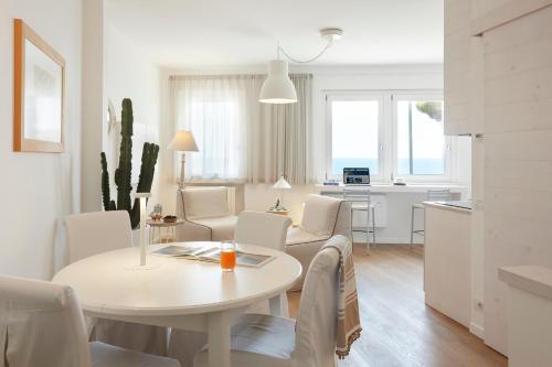 una sala de estar blanca con mesa y sillas en Maison del Bassotto, en Numana