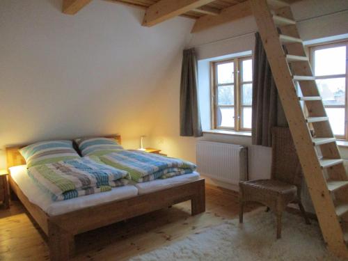 a bedroom with a bed and a ladder and windows at "Lütt Huus" in Ostermarkelsdorf