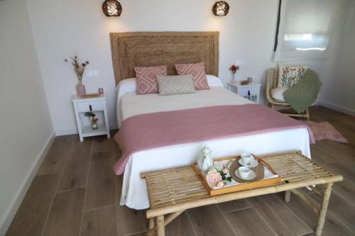 una camera da letto con un letto grande e un tavolo di Casa Rural Alegría de Toledo, Guadamur,Puy du Fou a Guadamur