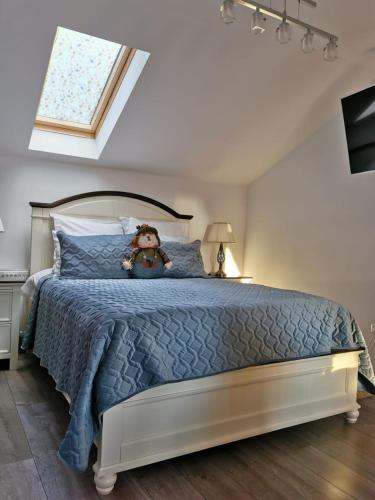 a teddy bear sitting on a bed in a bedroom at Apartament Fluturaș de Stâncă Comarnic in Comarnic