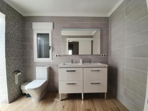 La salle de bains est pourvue de toilettes, d'un lavabo et d'un miroir. dans l'établissement Bungalow Aries, à Tías