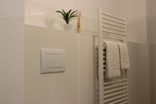 biała łazienka z wieszakiem na ręczniki i rośliną w obiekcie HR RoomS w Hanowerze