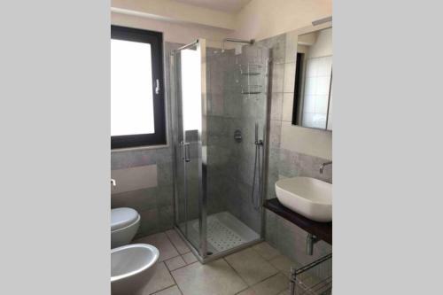 uma casa de banho com um chuveiro, 2 WC e um lavatório. em Masseria Mezza Ruota 2 em Alberobello