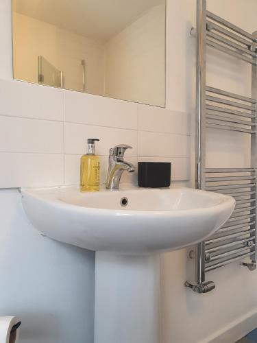 a white sink in a bathroom with a mirror at Cosy 2 Bedroom Reading House SLEEPS 6 - With FREE WiFi & Garden by Roost Accommodation in Reading