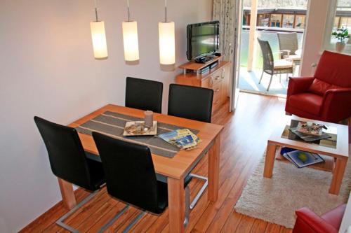 a living room with a dining room table and chairs at "Landhaus Voss" Typ 2 Nr6 in Staberdorf
