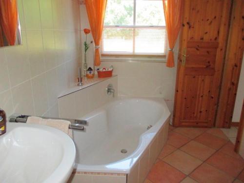 a bathroom with a white tub and a sink at Ferienwohnung Biernat in Prinzenmoor