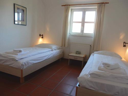 two beds in a small room with a window at Ferienparadies Rugana D07 in Kreptitz