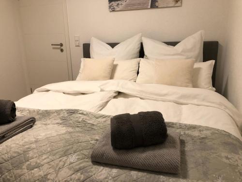 uma cama grande com lençóis brancos e almofadas brancas em Exklusive moderne 2 Zi. Wohnung in ruhiger Lage em Rastatt