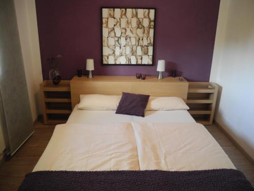 ein Schlafzimmer mit einem großen weißen Bett mit lila Wänden in der Unterkunft PatRei mit Meerblick, auch beim Duschen in Eckernförde