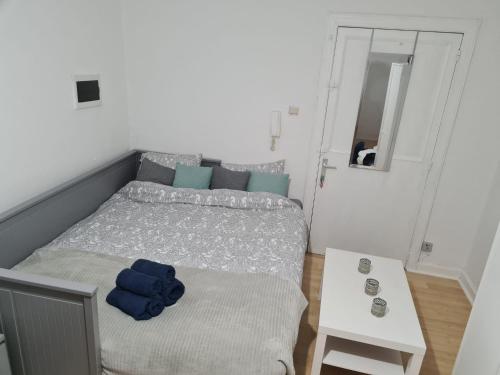 a small bedroom with a bed and a table at Cosy 1 & 2 parking et wifi gratuits in Charleroi