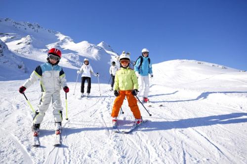 a group of people skiing down a snow covered slope at Chalet Zolota Pidkova in Slavske