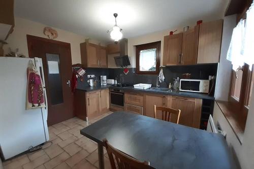 une cuisine avec une table et un réfrigérateur dans l'établissement Rustic & A Chalet 'Le Sert du Grey - Vaujany, à Vaujany