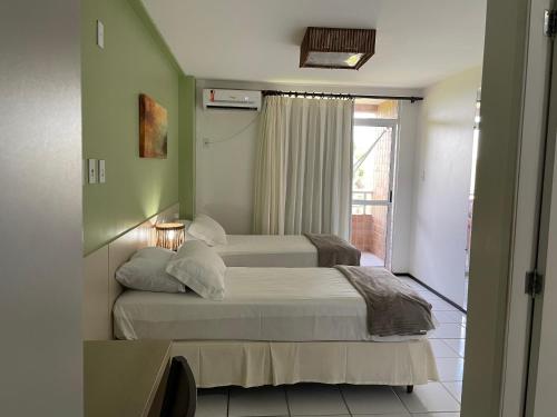 a bedroom with two beds and a window at Barreirinhas Lençois Flat in Barreirinhas