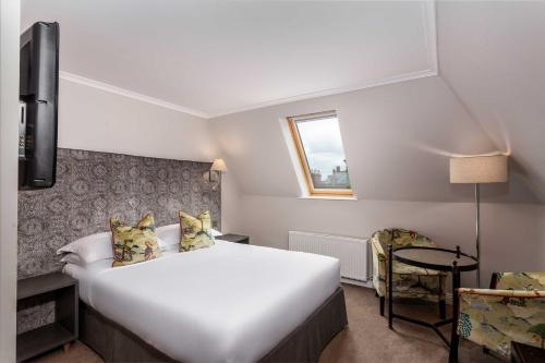 a hotel room with a large white bed and a window at The Beaumont Hexham in Hexham