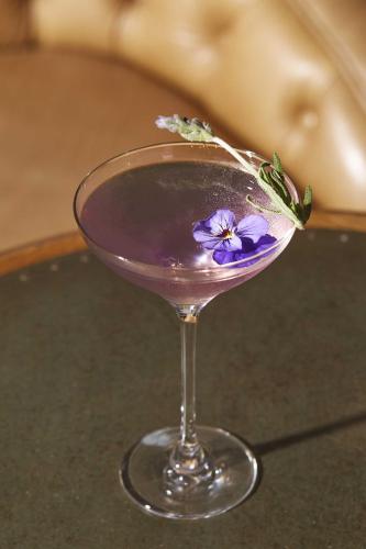 a glass with a purple drink with a purple flower on it at The Beaumont Hexham in Hexham