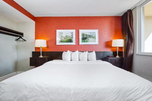 a large white bed in a room with two lamps at Town Inn Suites Hotel in Toronto
