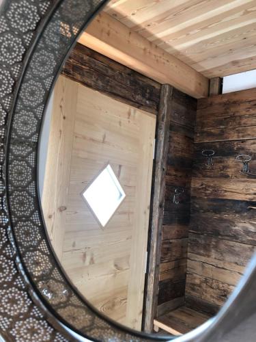 espejo reflejo de una habitación de madera con ventana en Ringgelinhof Onach en San Lorenzo di Sebato