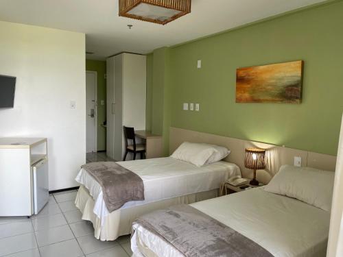 um quarto de hotel com duas camas e uma mesa em Barreirinhas Lençóis Flat Residence em Barreirinhas