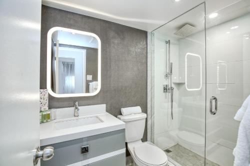 W łazience znajduje się toaleta, umywalka i prysznic. w obiekcie Town Inn Suites Hotel w mieście Toronto