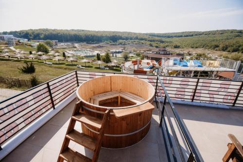 a wooden tub sitting on top of a balcony at Cabana Suzanne Băile Figa-cu aer conditionat in Agrişu de Sus