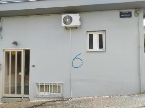 a white garage door with a window and a fan at FLAT with Private Rooms in Agrinion