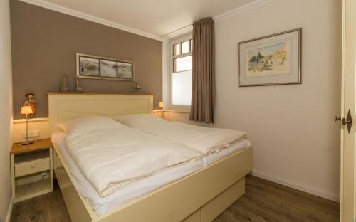 een slaapkamer met een bed, een bureau en een raam bij Quisisana10 in Sankt Peter-Ording