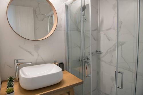 a bathroom with a sink and a shower with a mirror at The Little big apartment in the heart of Heraklion in Heraklio