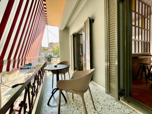 a balcony with a table and chairs and a window at K8 Athens in Athens