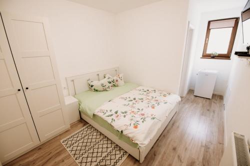 a small bedroom with a bed and a dresser at Suzanne Băile Figa- camere tip hotel in Beclean