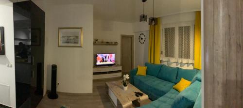 un soggiorno con divano blu e TV di Apartman "Park" a Livno