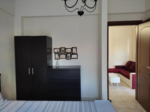セレスにあるAnastasia's & Despoina's Apartmentのベッドルーム(黒いキャビネット、赤いソファ付)