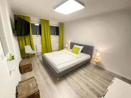 - une chambre avec un lit et un rideau vert dans l'établissement Appartement Apelern (A2) - 2 Zimmer, Badewanne, Terrasse, Netflix, à Apelern