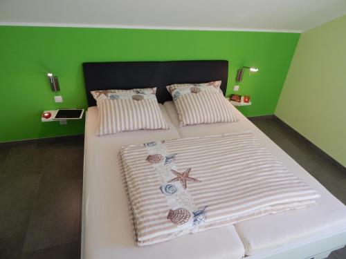 LebbinにあるLuxus FH "Seekiste" mit 38C Außenwhirlpoolの緑の壁のベッドルーム1室(白いベッド1台付)