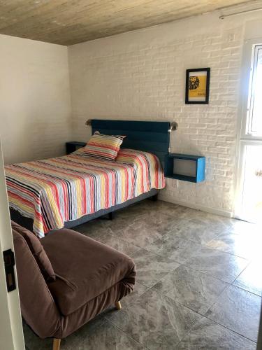 a bedroom with a bed and a chair at Las Olas Aparts in La Paloma