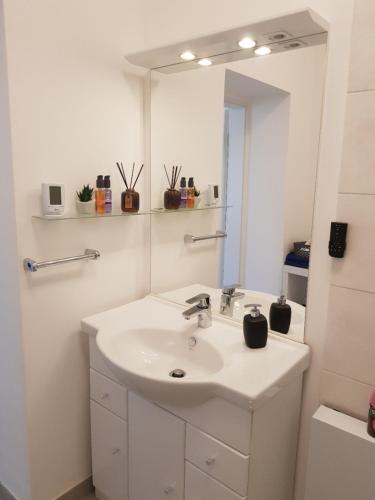 W białej łazience znajduje się umywalka i lustro. w obiekcie Apartment Deluxe, inklusive WLAN, Parkplatz und Netflix w mieście Schleiden