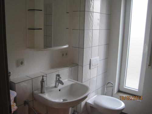 een witte badkamer met een wastafel en een toilet bij Ferienwohnung-Haus-Perkow - 72818 in Illingen