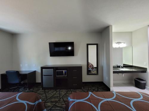 a hotel room with a bed and a sink and a television at Best Inn Motel Salina in Salina